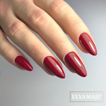 Main portant le vernis semi-permanent Elyamaje n°70 – Romantic, rouge profond élégant.