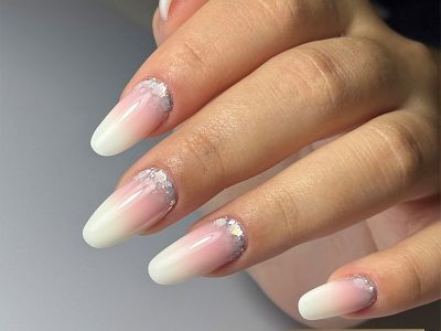 Babyboomer blanc laiteux avec paillettes crystal argentées à la base de l’ongle.