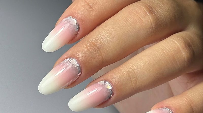 Babyboomer blanc laiteux avec paillettes crystal argentées à la base de l’ongle.