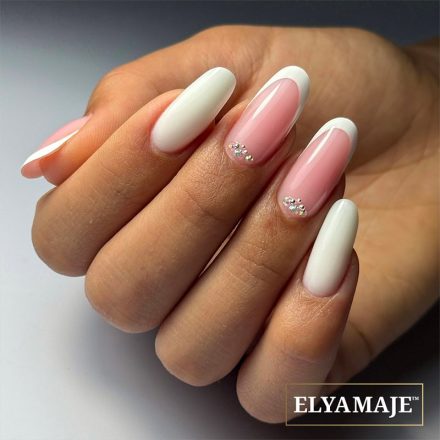 Pose ongulaire French Crystal avec French blanche et cristaux argentés en accent, sur ongles longs.