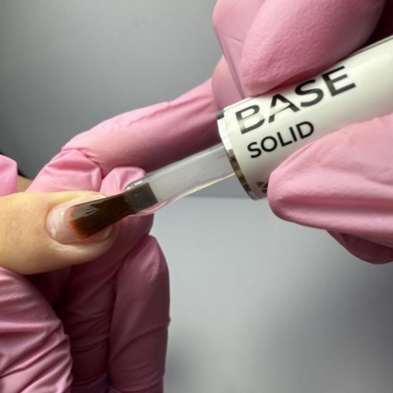 Application d'une base sur un ongle.
