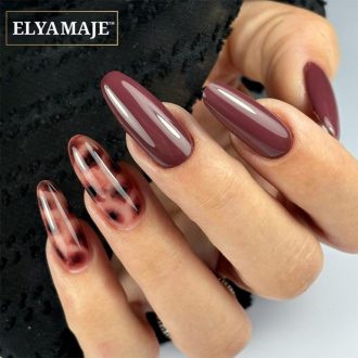 Ongles longs en forme amande avec vernis bordeaux brillant et accent nails tortoise.